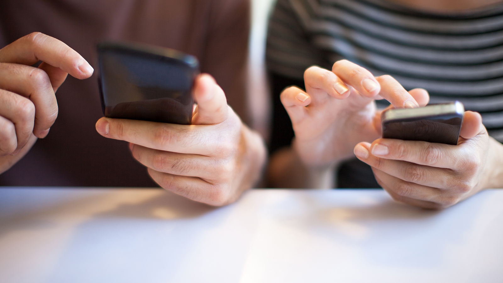Two people using responsive websites on smartphones