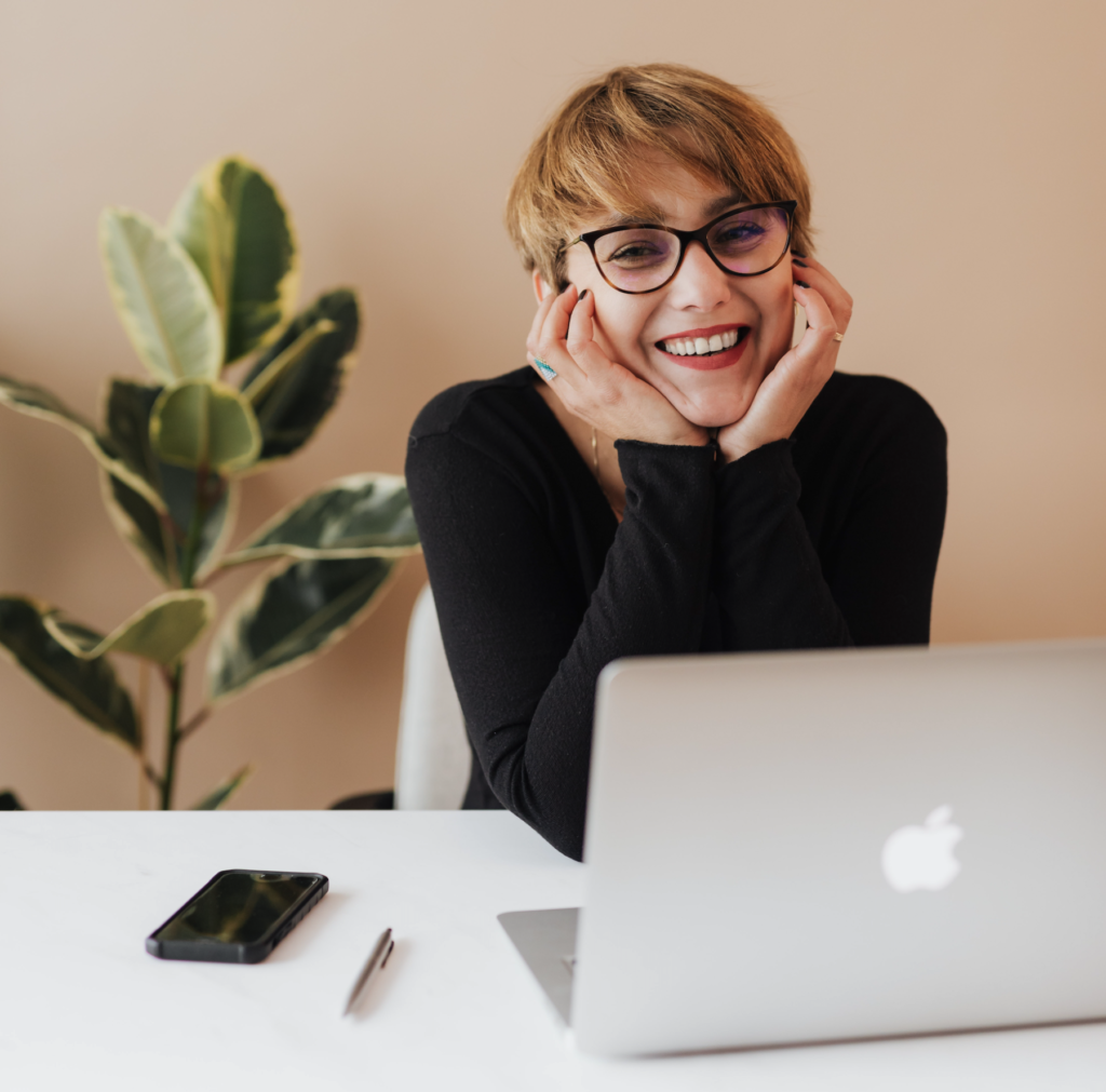 Woman behind laptop smiling