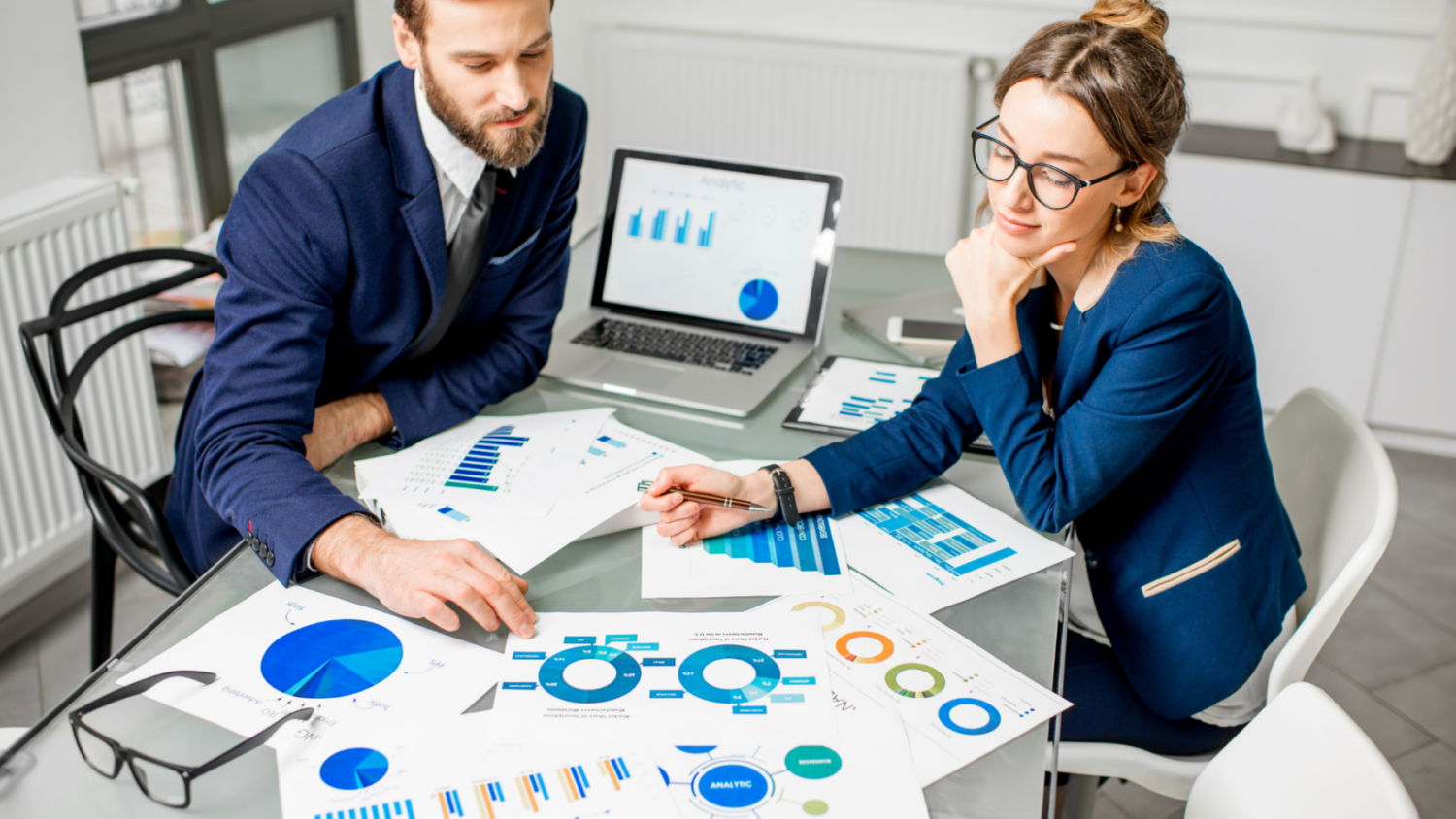 Man and woman comparing graphs