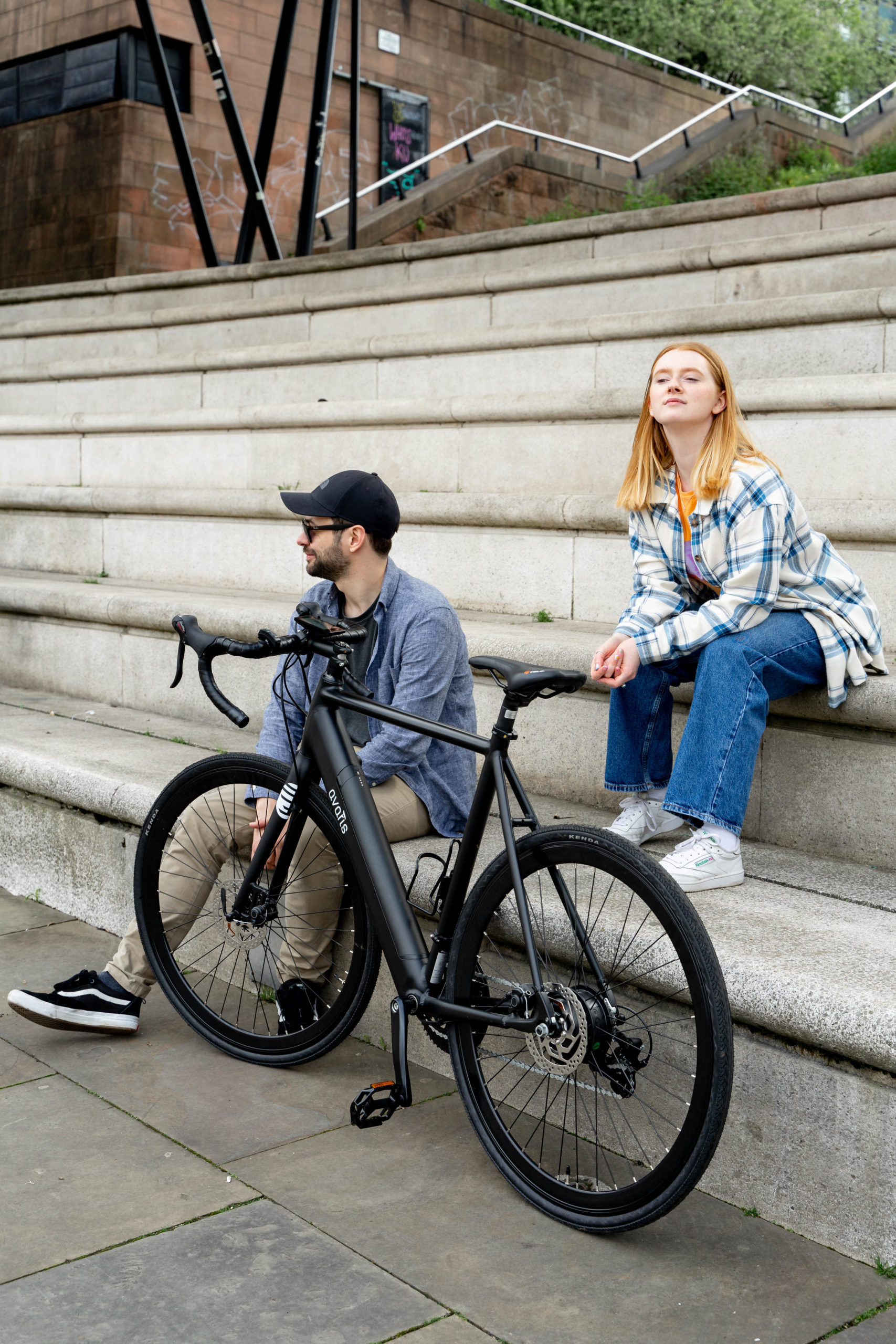 two friends laughing with a bicycle