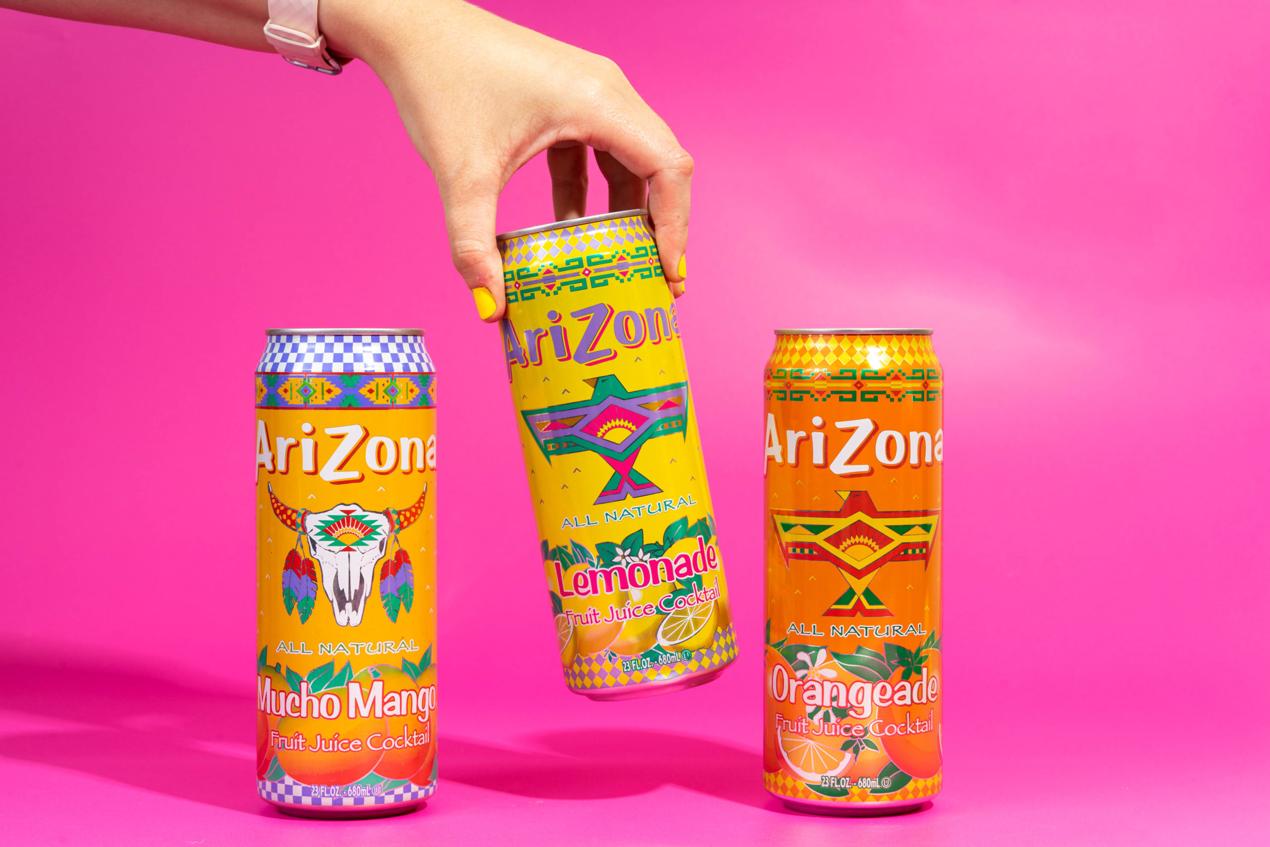 Canned fizzy drinks on a bright pink background
