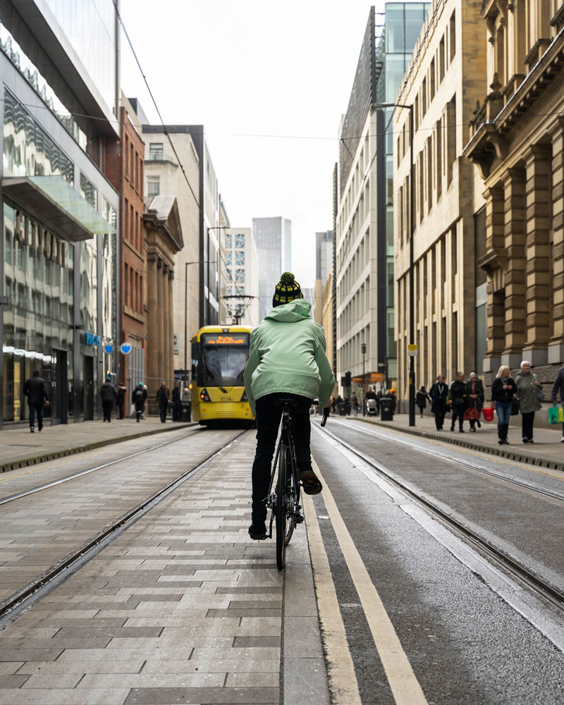 man cycling down a city centre road