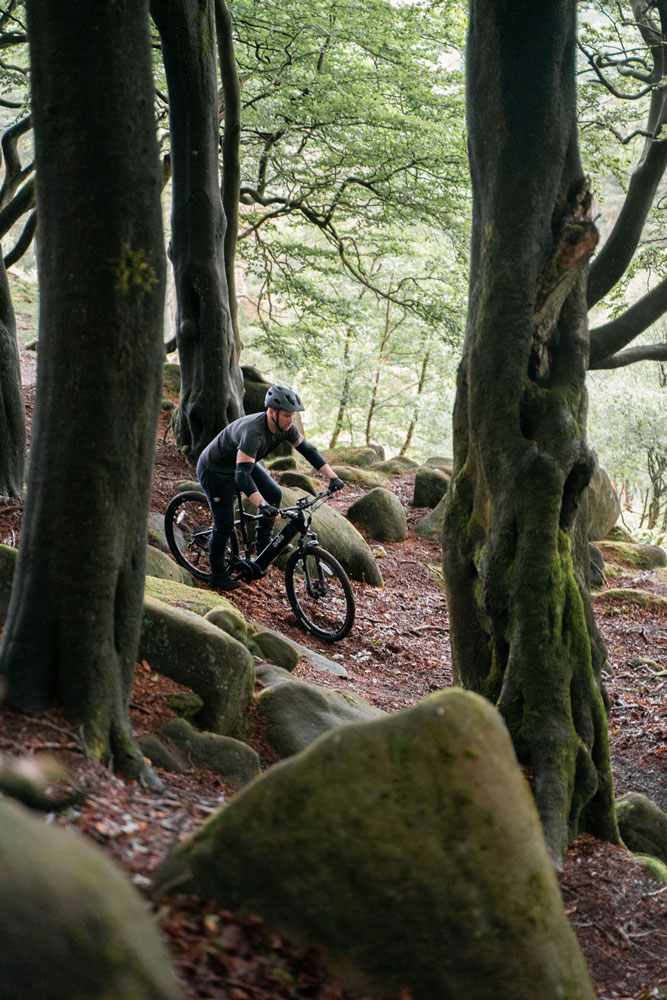 man on a mountain ebike in wooded area photography