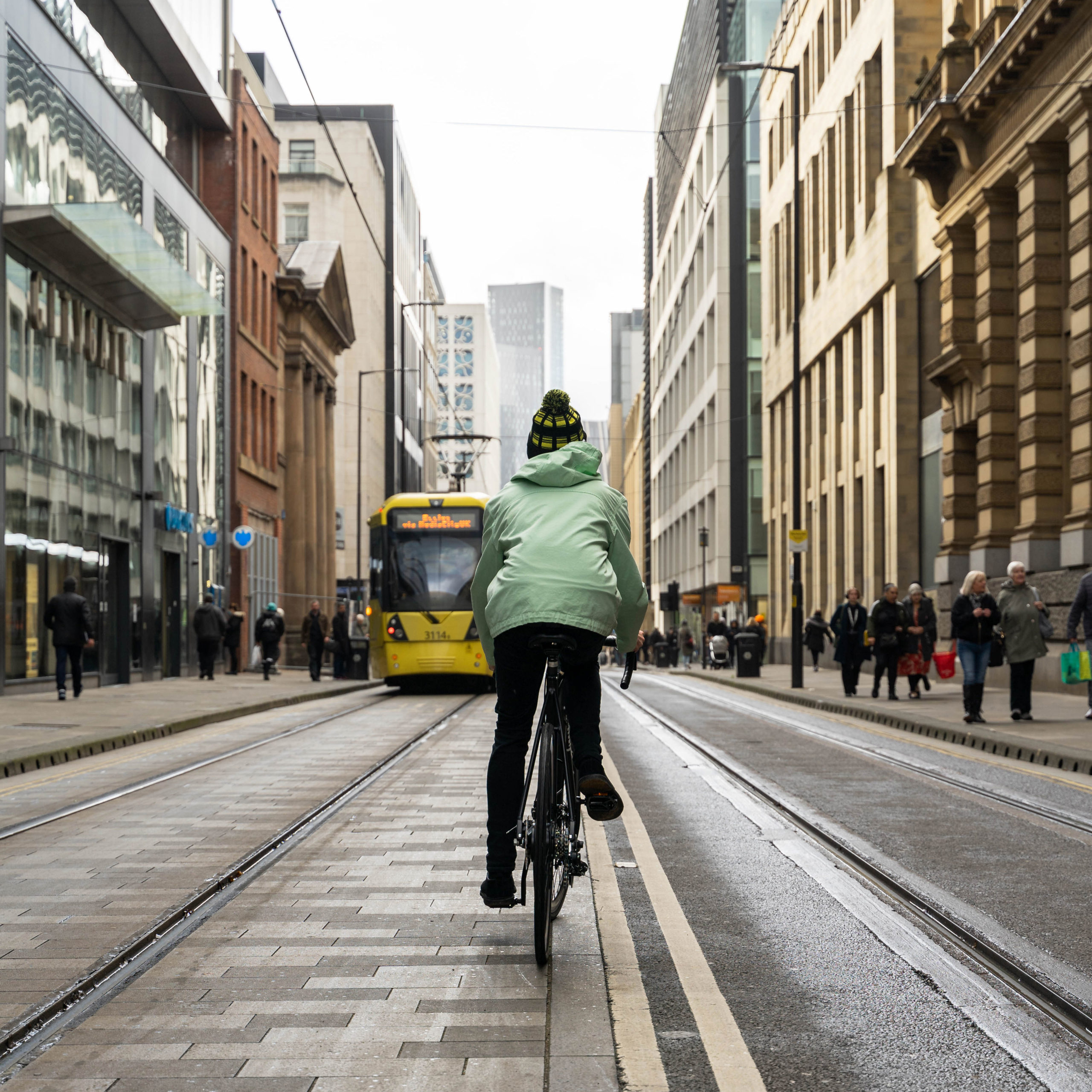 Man riding a bike down a Manchester road